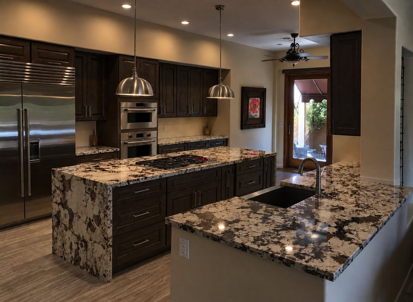 Kitchen with dark wood cabinets, stainless appliances, and a waterfall-edge island in bold black and cream stone