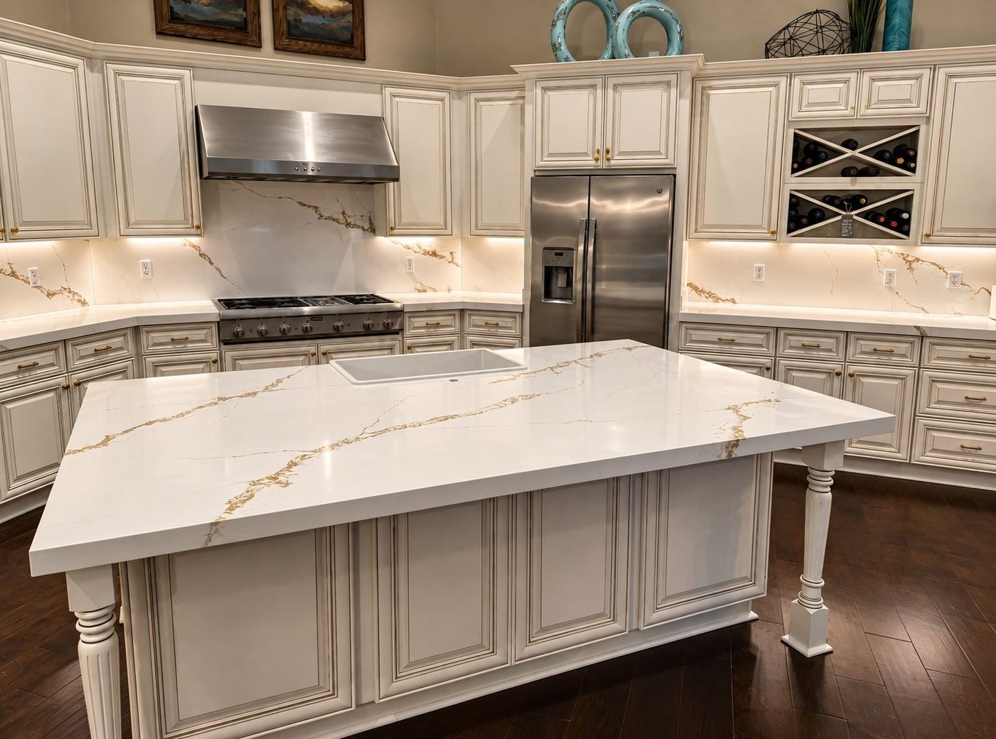 Traditional cream kitchen with a large island in white stone with gold veining and a matching slab backsplash